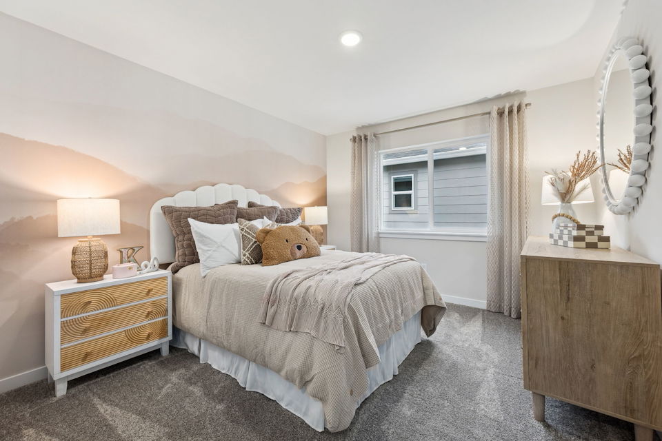 A bedroom with a bed and a dresser.