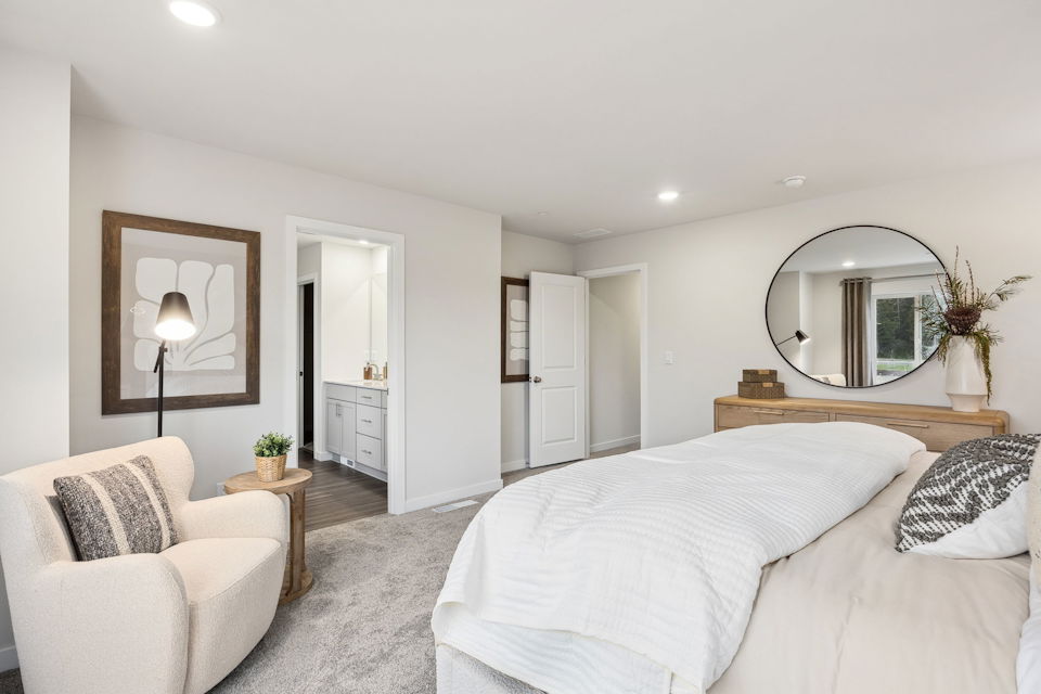 A bedroom with a bed and a mirror.