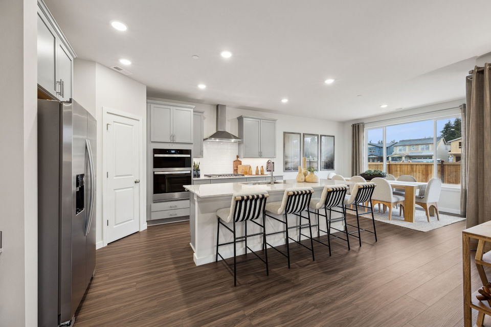 A kitchen with a dining table and chairs.