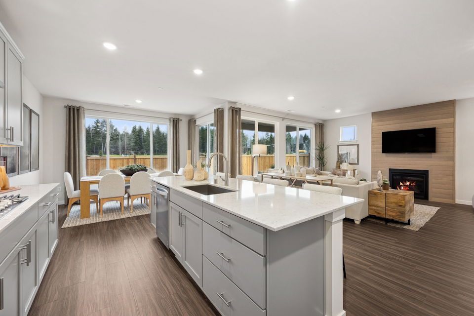 A kitchen with a fireplace and a large window.