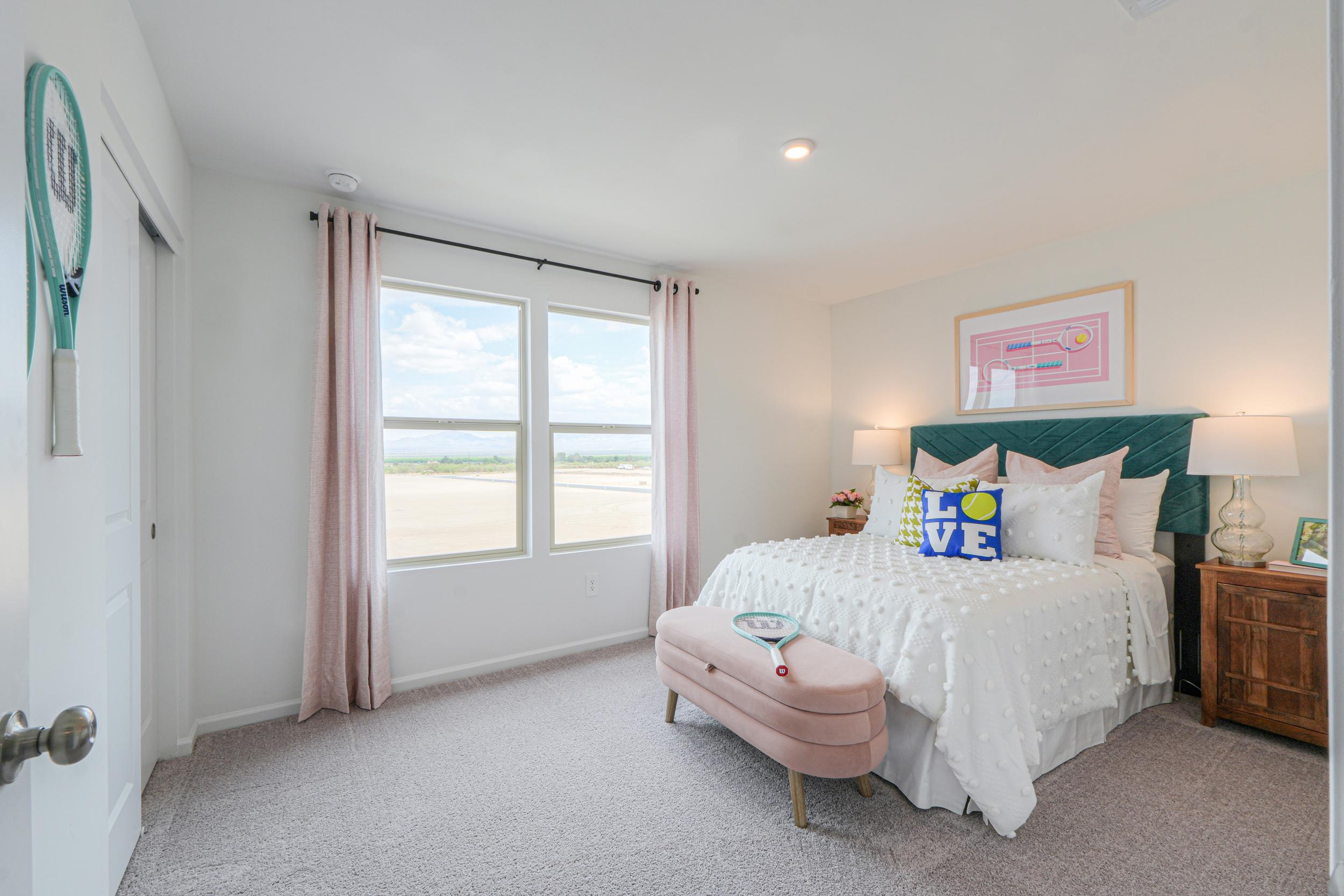 A bedroom with a bed and a bench.