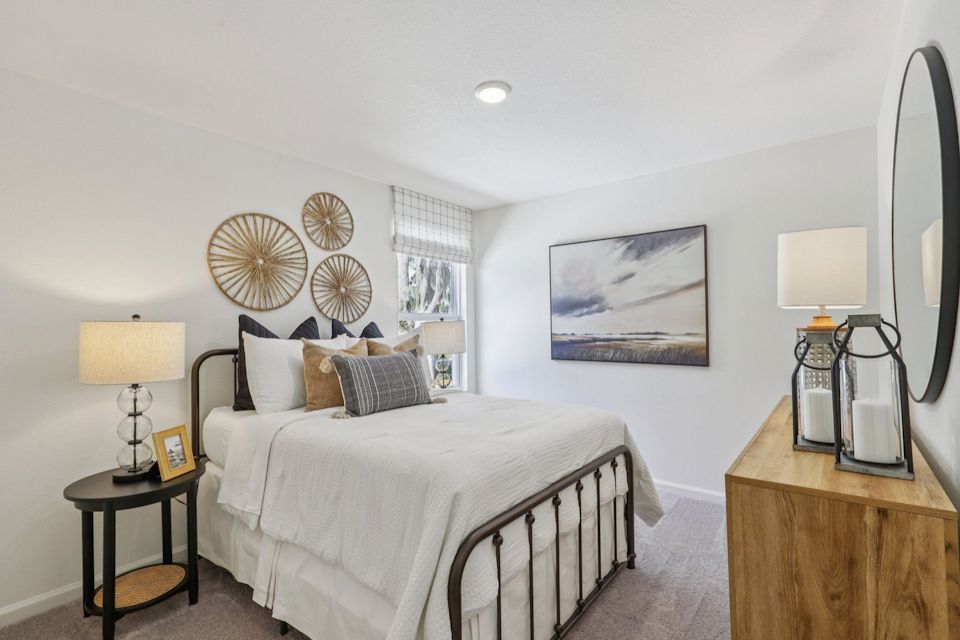 A bedroom with a bed and lamps.