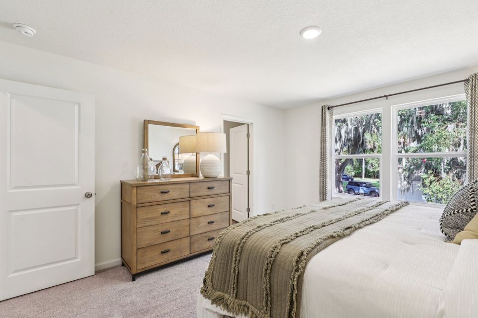 A bedroom with a bed and dresser.