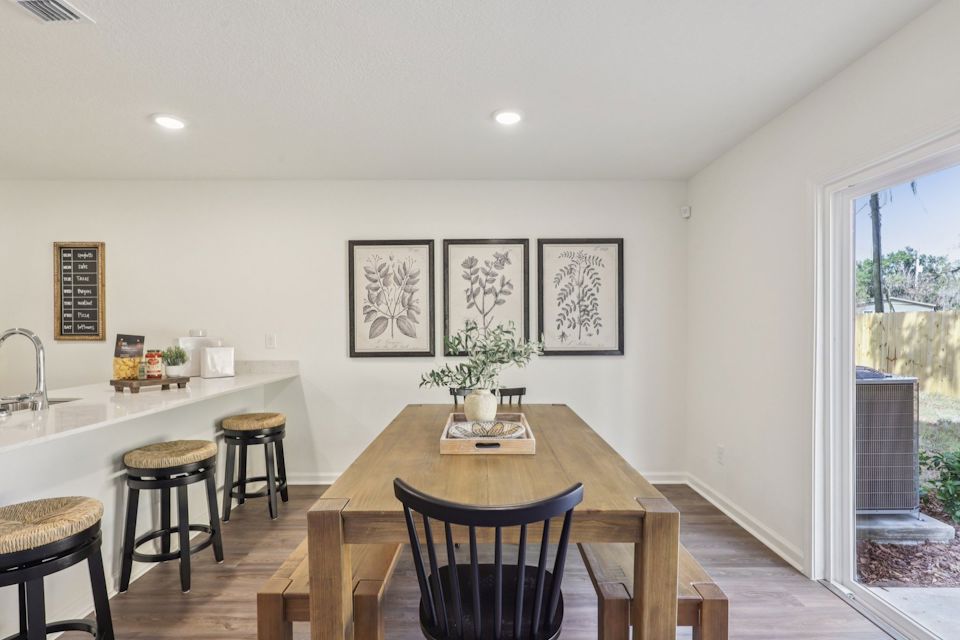 A kitchen with a table and chairs.