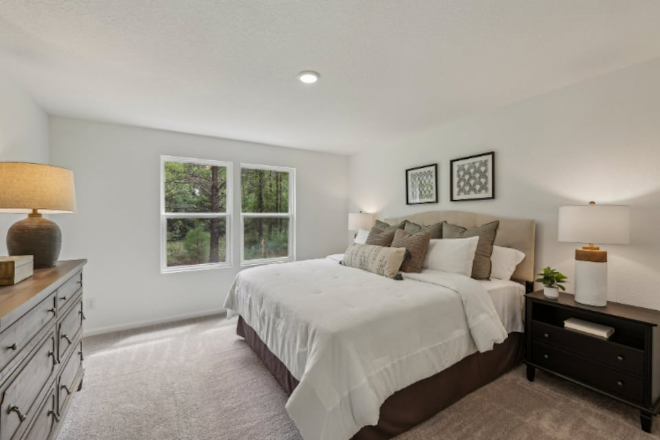 A bedroom with a bed and lamps.