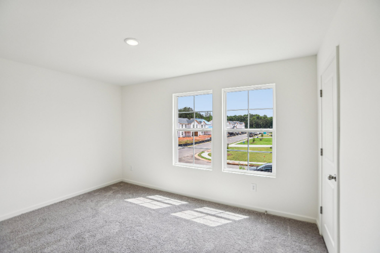 A room with a window and a carpet.