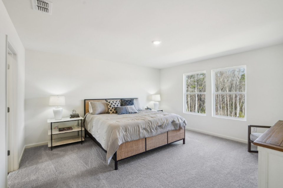 A bedroom with a bed and lamps.