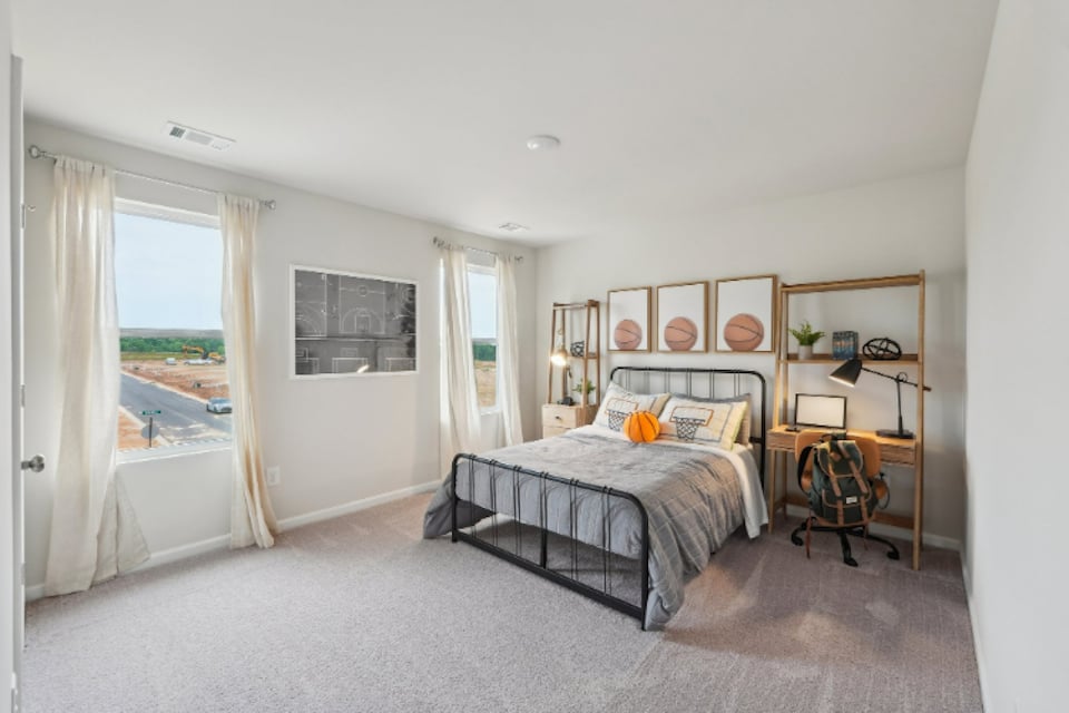 A bedroom with a bed and a desk.