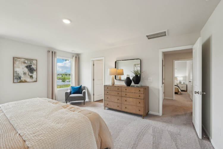 A bedroom with a bed and a chair.