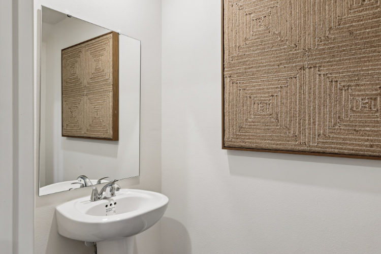 A bathroom with a mirror and a sink.