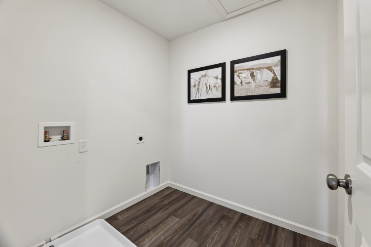 A room with a wood floor and pictures on the wall.