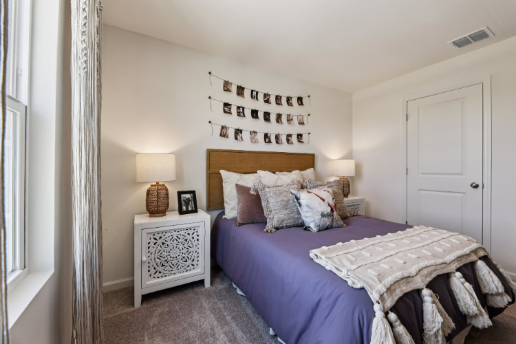 A bedroom with a bed and a lamp.