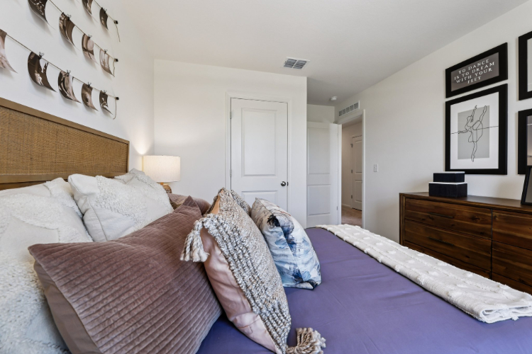 A bedroom with a bed and a dresser.