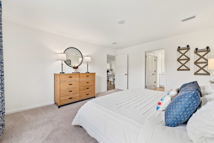 A bedroom with a bed and a dresser.