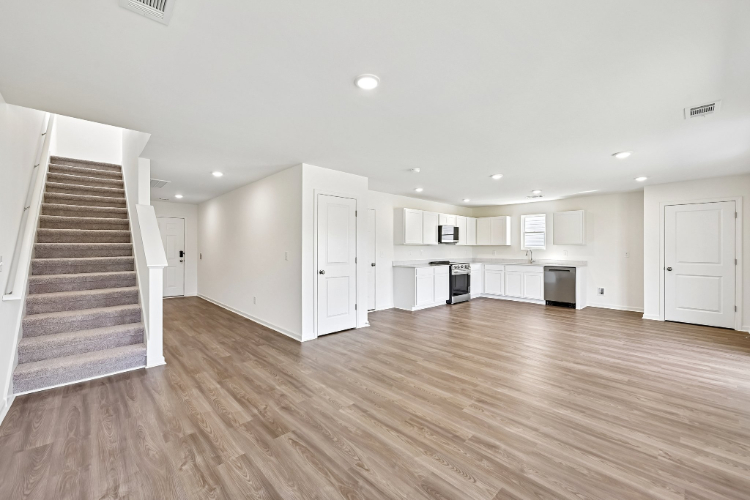 A large empty room with white cabinets.