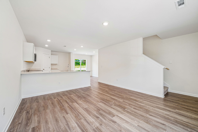 A room with white walls and wood floors.