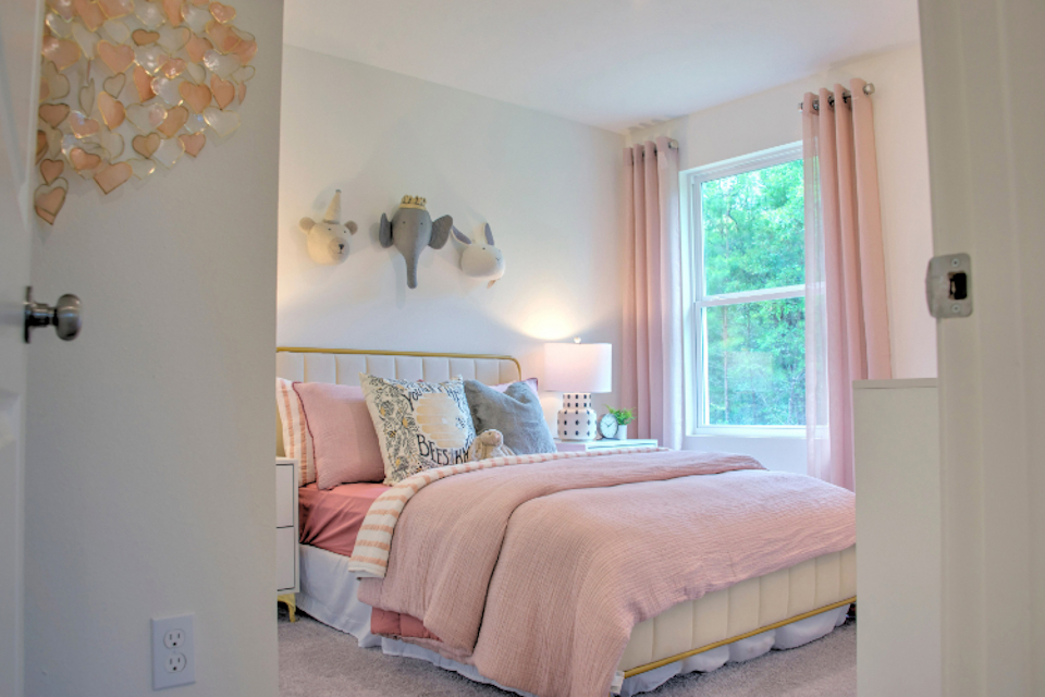 A bedroom with a pink bed.