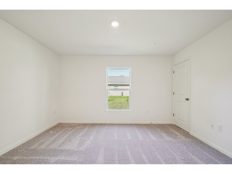 A room with a window and a carpet.