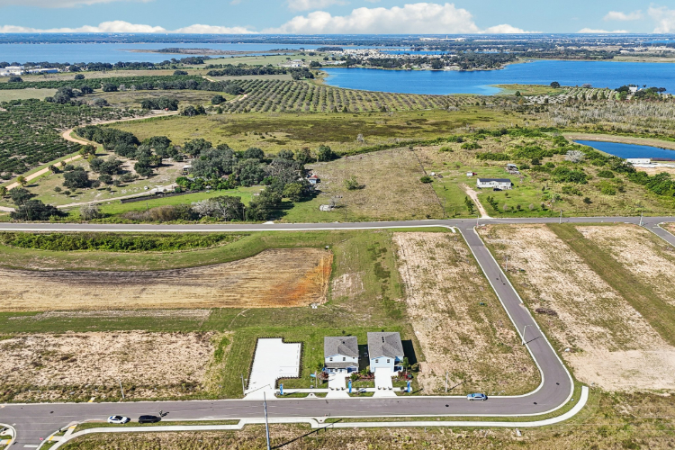 A road with a building and a body of water in the background.