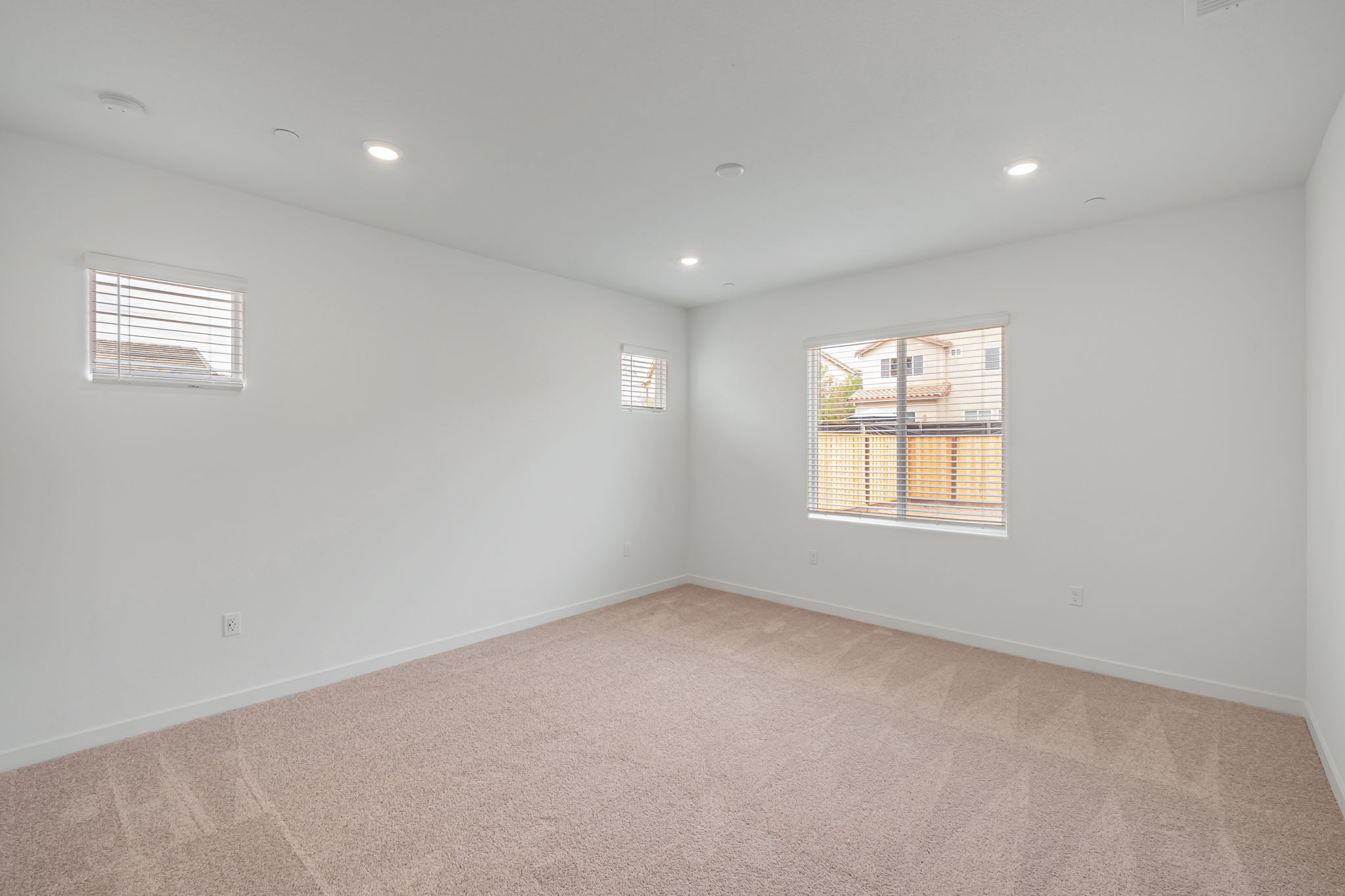 A room with a carpet and windows.