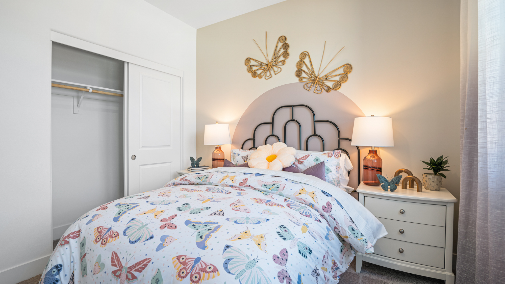 A bedroom with a bed and lamps.